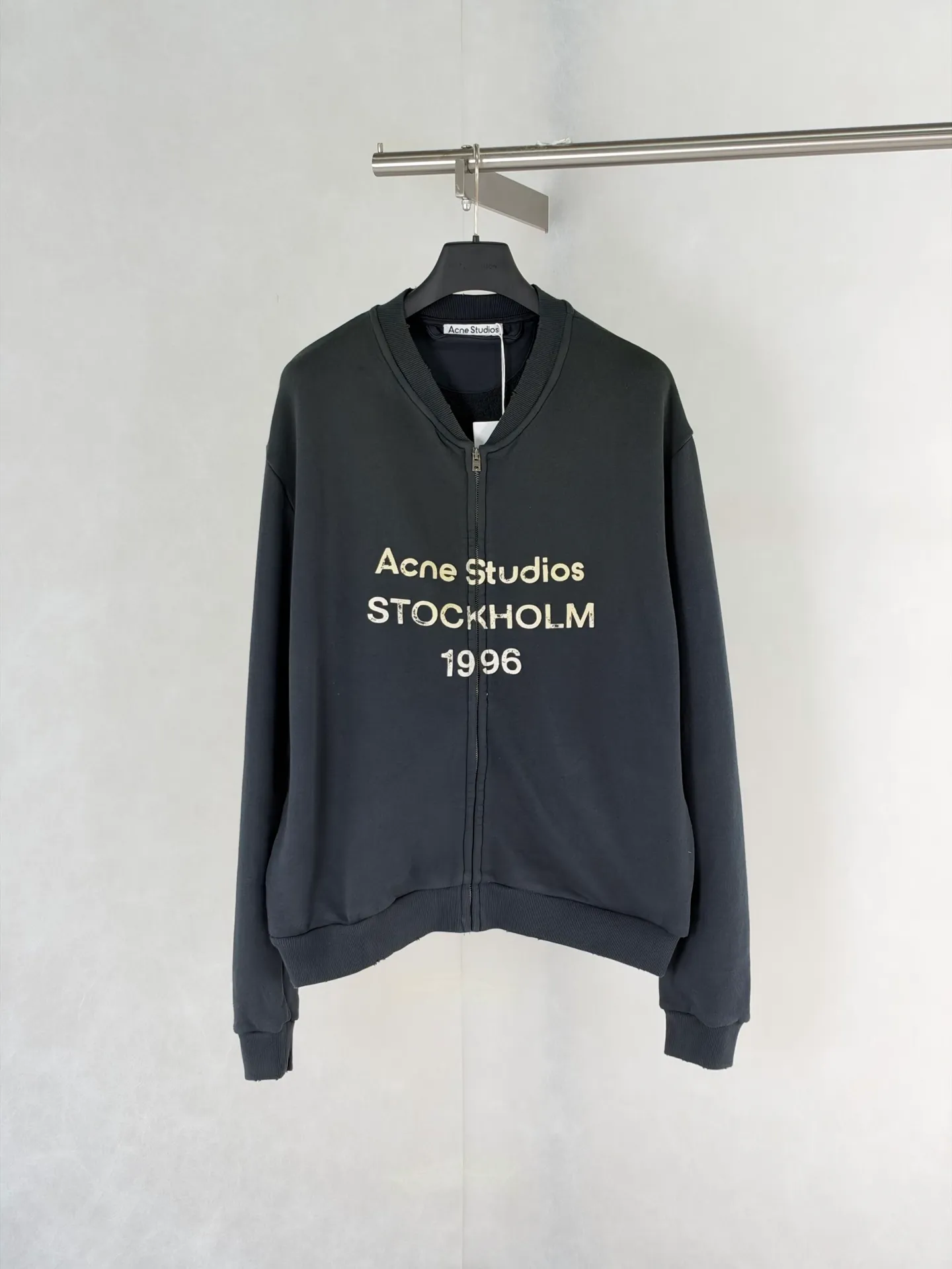Acne Studio distressed washed zipper baseball sweatshirt is made of 100% cotton terry cloth, garment washed + distressed and sanded. The body adopts dropped shoulder sleeves, a loose oversize silhouette, a V-shaped ribbed baseball collar design, and the edge of the collar is deliberately frayed and damaged. The main zipper is made of distressed metal zipper, and the front panel is positioned with glue crack printing. Size: S/M/L/XL